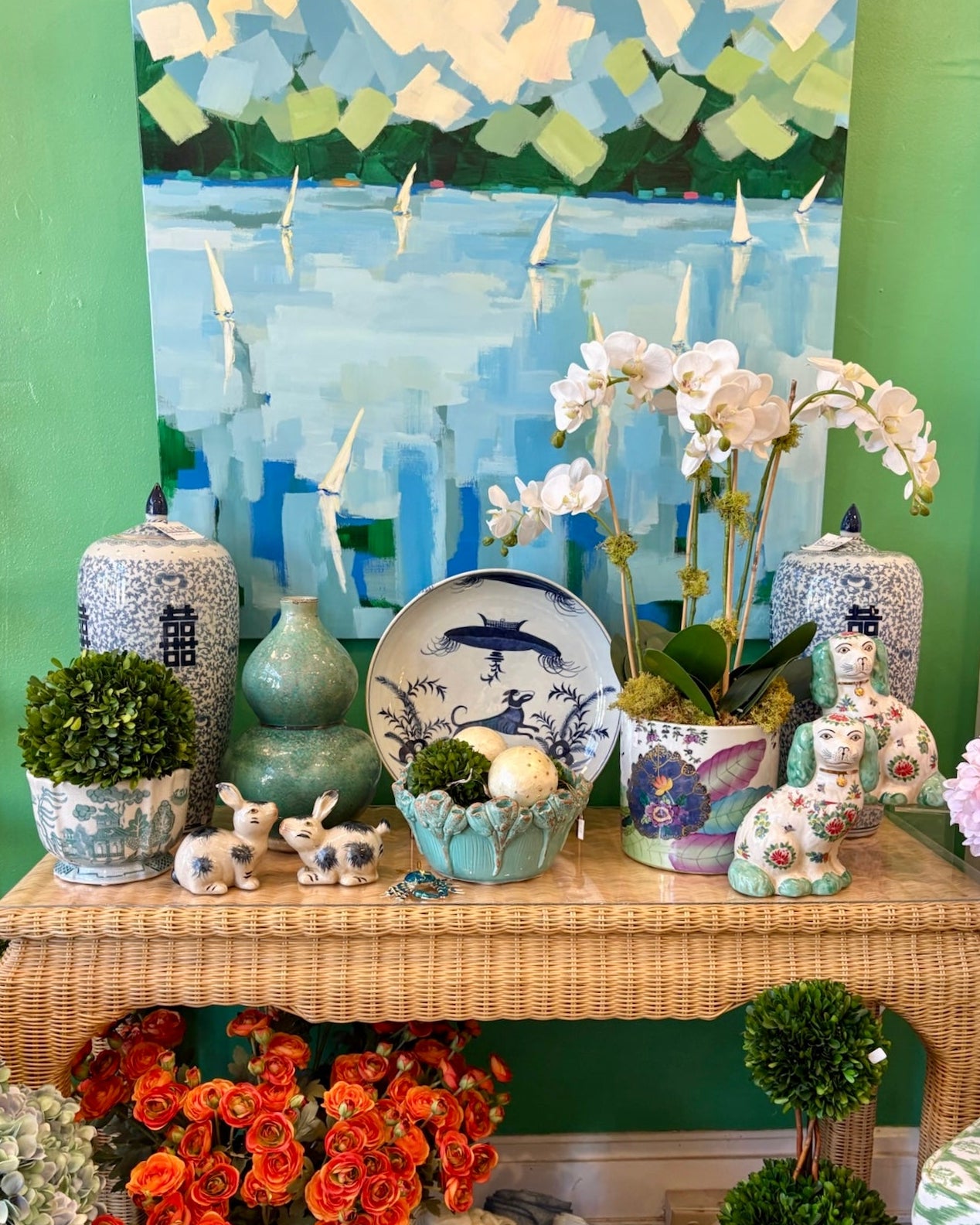 Decorative table with various items including vases, flowers, and a painting of a landscape.