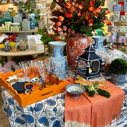 Decorative table setting with floral arrangement, lantern, and glassware in a store setting.
