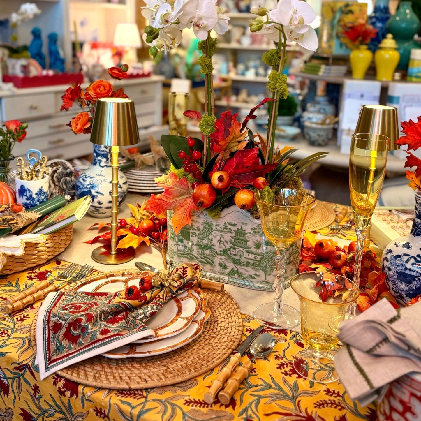 Decorative table setting with flowers, glasses, and plates in a store setting.