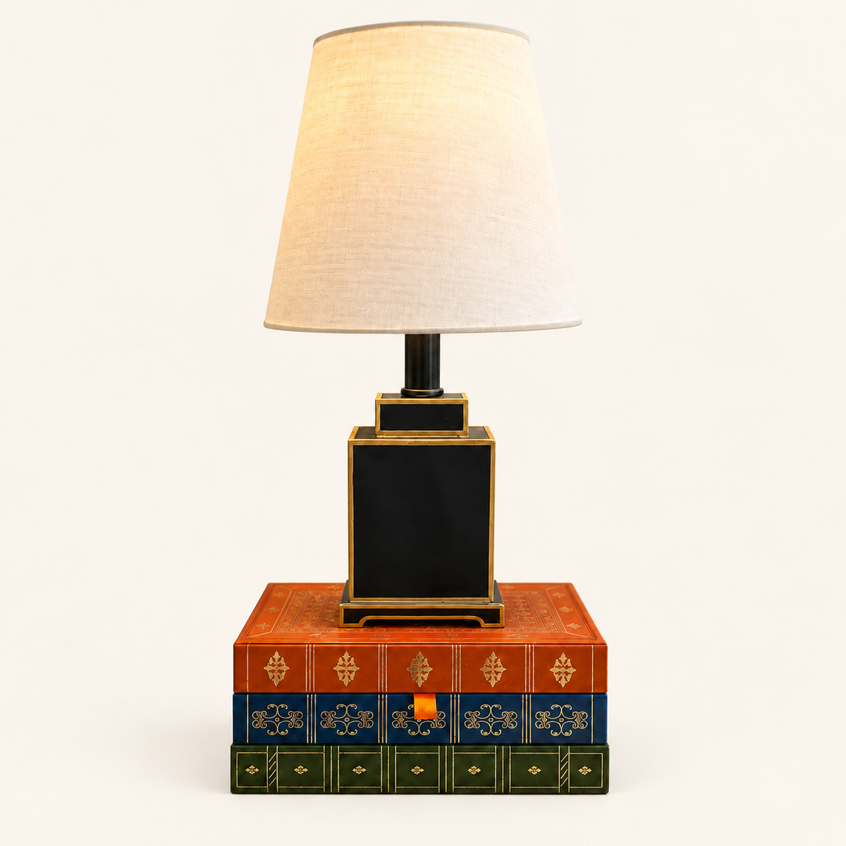 Mini Tole Tea Jar Lamp in Black with gold trim and a linen shade, styled on decorative books