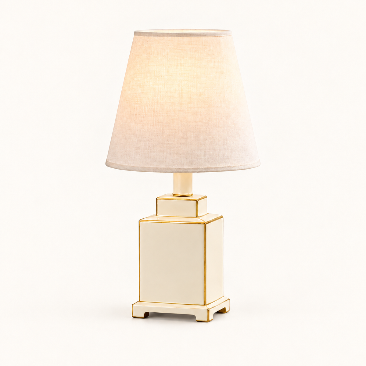 Mini Tole Tea Jar Lamp in Cream with gold trim and a linen shade, on an ivory studio background
